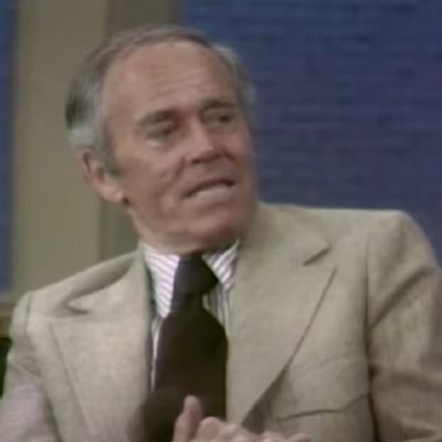 Henry Fonda can be seen wearing a grey suit with black tie in the picture.